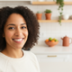 A happy North American woman in her 30s smiles at the camera, conveying trust and satisfaction.